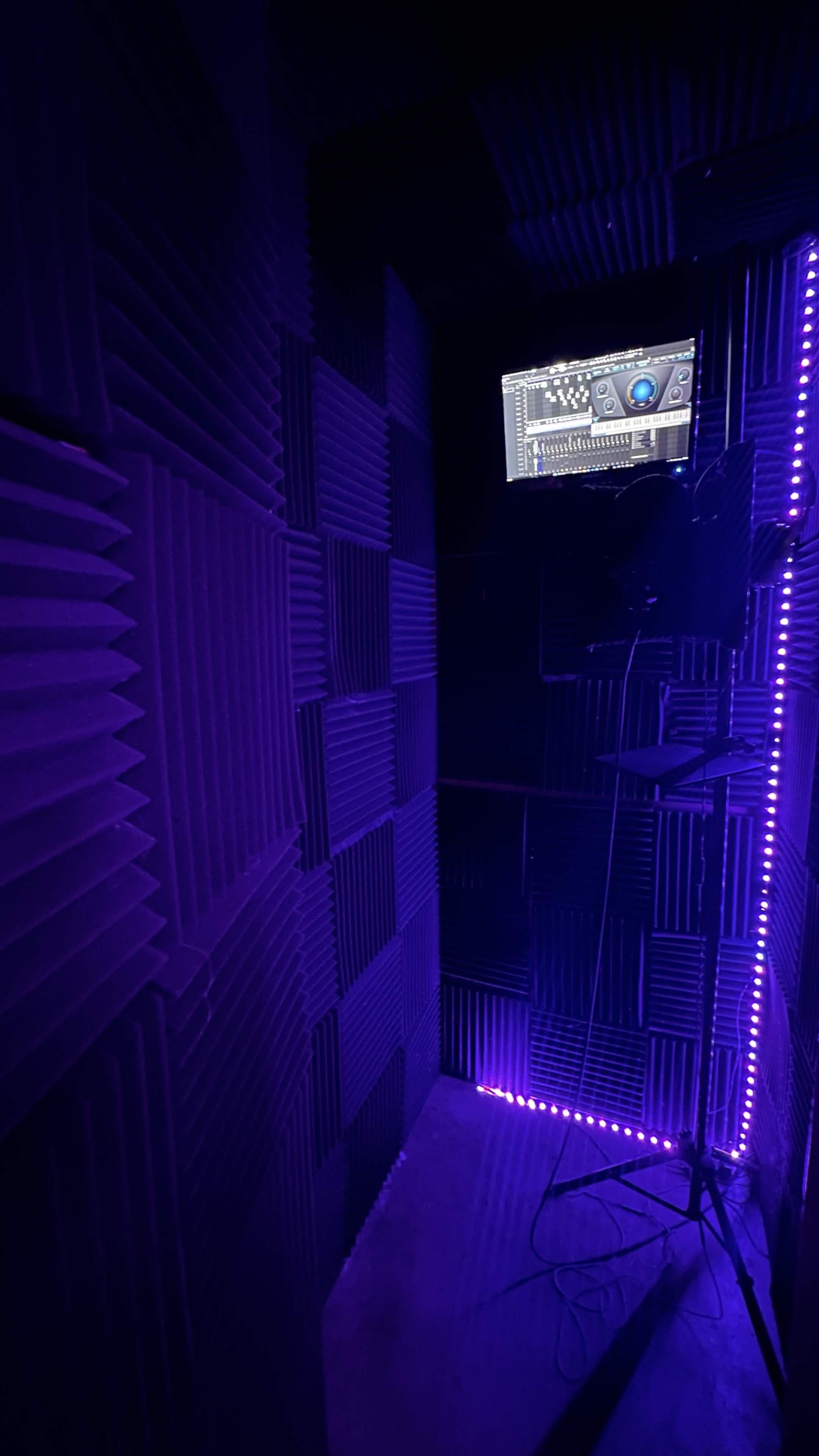 Inside the treated vocal booth — acoustic foam and LED lighting